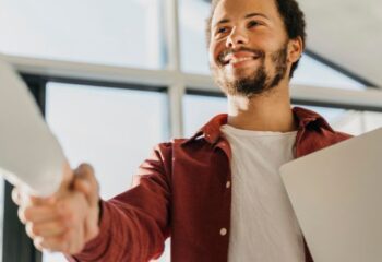Colegas de trabalho frente a frente apertando as mãos