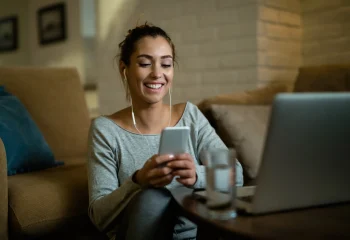 mulher-sorrindo-fones-ouvido-smartphone-sofa.jpg